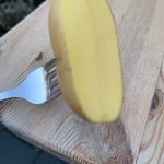 Eine halben Kartoffel auf einer Gabel zum reinigen des Grill Rosts