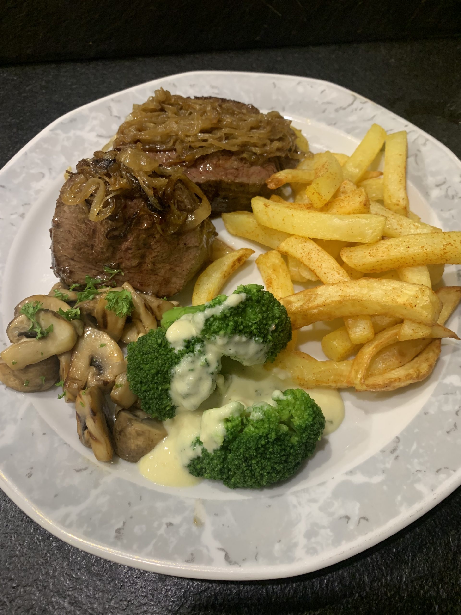 Zwiebelsteak mit Brokkoli in Parmesansauce und Pommes Frites