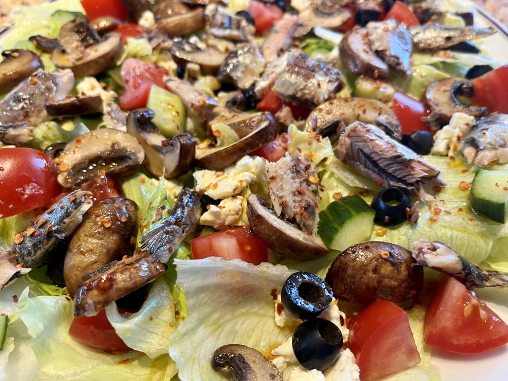 Eisbergsalat mit gebratenen Champignons und Sardinenfillets