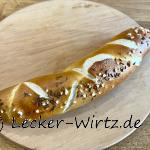 Eine Kümmel-Laugenstange auf einem runden Holzbrett