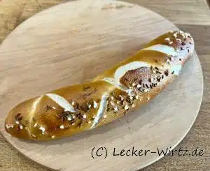 Eine Kümmel-Laugenstange auf einem runden Holzbrett