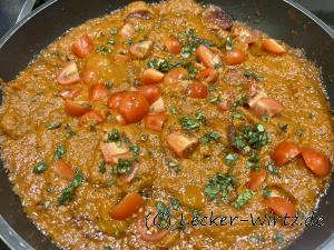 Mit der Tomatensauce und den Kirschtomaten vermischen