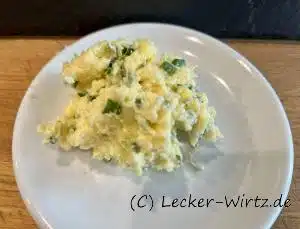 Auf einem weißen Teller befindet sich Schnittlauch-Parmesan Butter