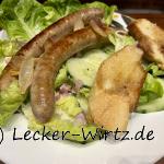 Chipolatas auf Salat mit geröstetem Baguette