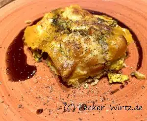 Ein Stück Kürbis-Polenta-Tarte mit Mangold und Kürbiskernöl