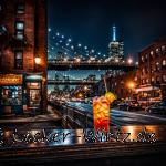 Abends in New York City, Bronx ein Cocktail Namens Bronx mit Blick auf eine Brücke im Hintergrund.