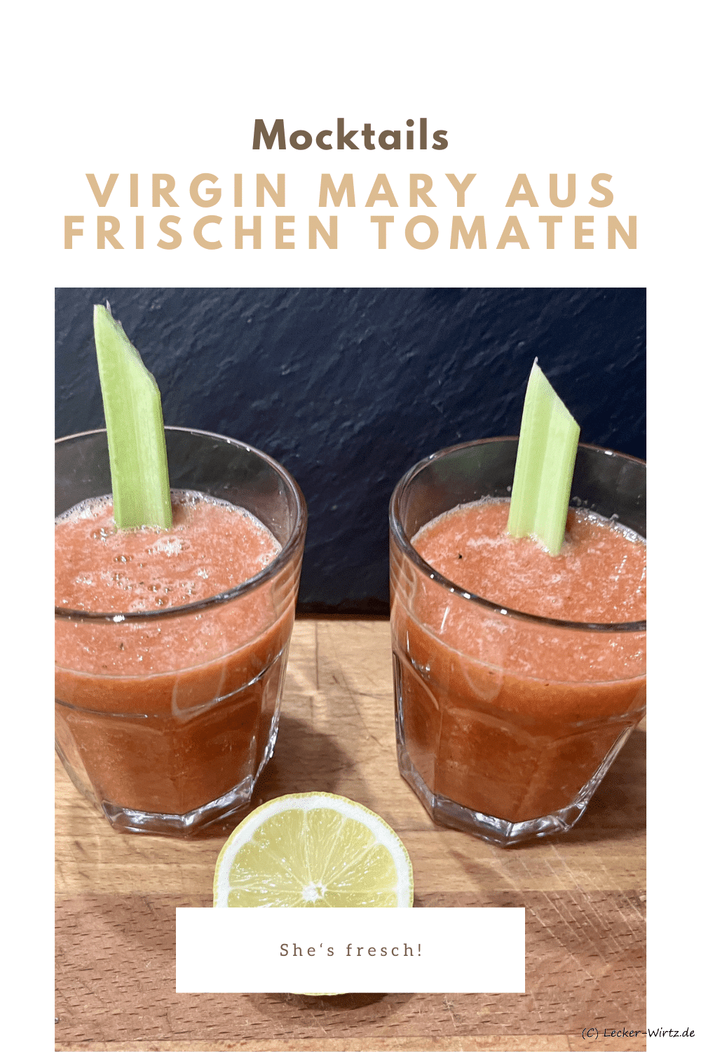 Zwei Virgin Mary aus frischen Tomaten, garniert mit einer Selleriestange, im Glas auf einem Holzbrett vor einer Schiefertafel und eine halbe Zitrone.
