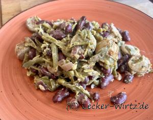 Auf einem roten Teller sind grüne Bohnen. Kidneybohnen und Bratwurst scheiben untereinander angerichtet.