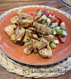 Crosses Hähnchenfleisch mit Gurke-Tomatensalat